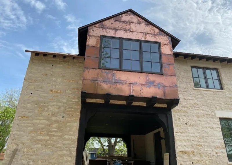 Copper metal panel facade on a stone building for Skylight Installation in East Lyme
